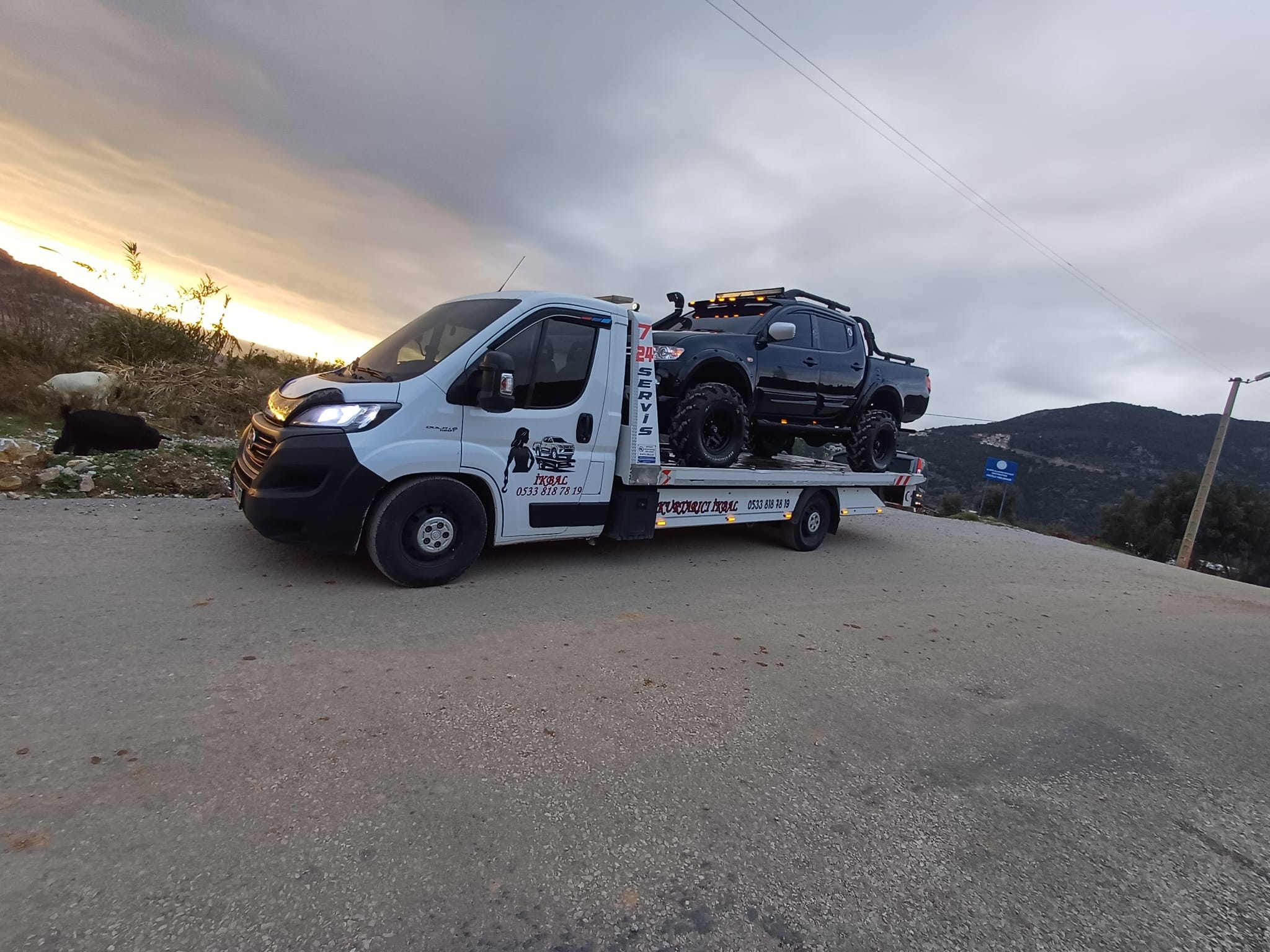 Dağ yolunda pickup araç taşıyan oto çekici ve yol yardım hizmeti